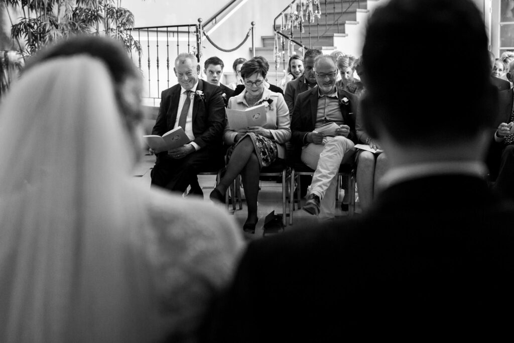 Ouders kijken tijdens de ceremonie naar hun kinderen.