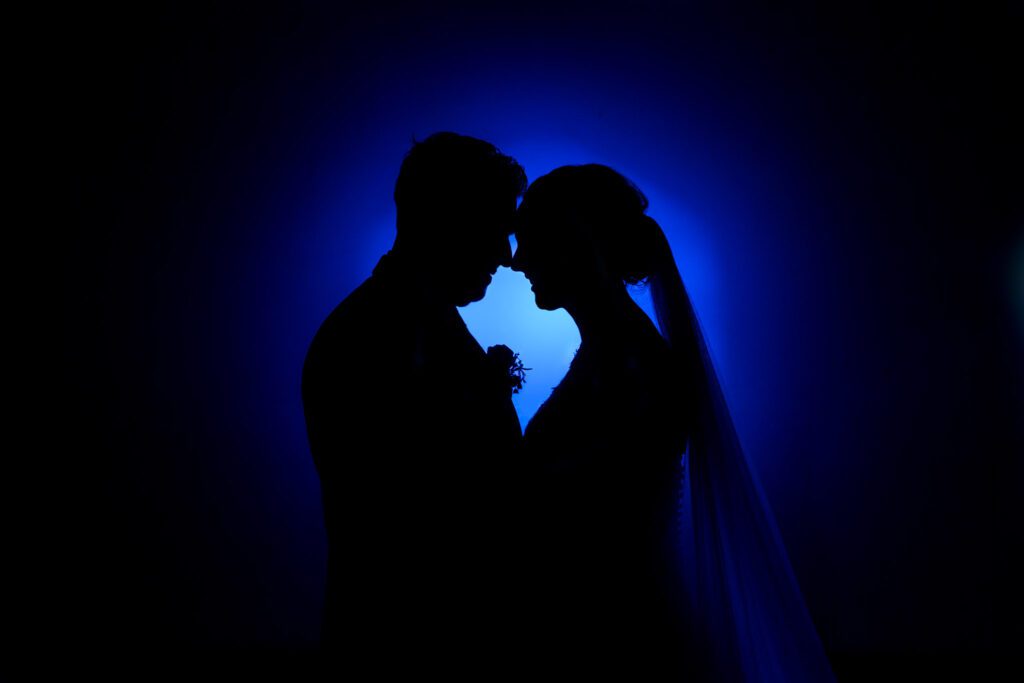 Silhouette van een bruidspaar voor een blauwe achtergrond.