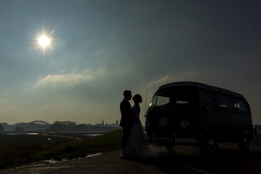 Silhouette van een kussend bruidspaar.