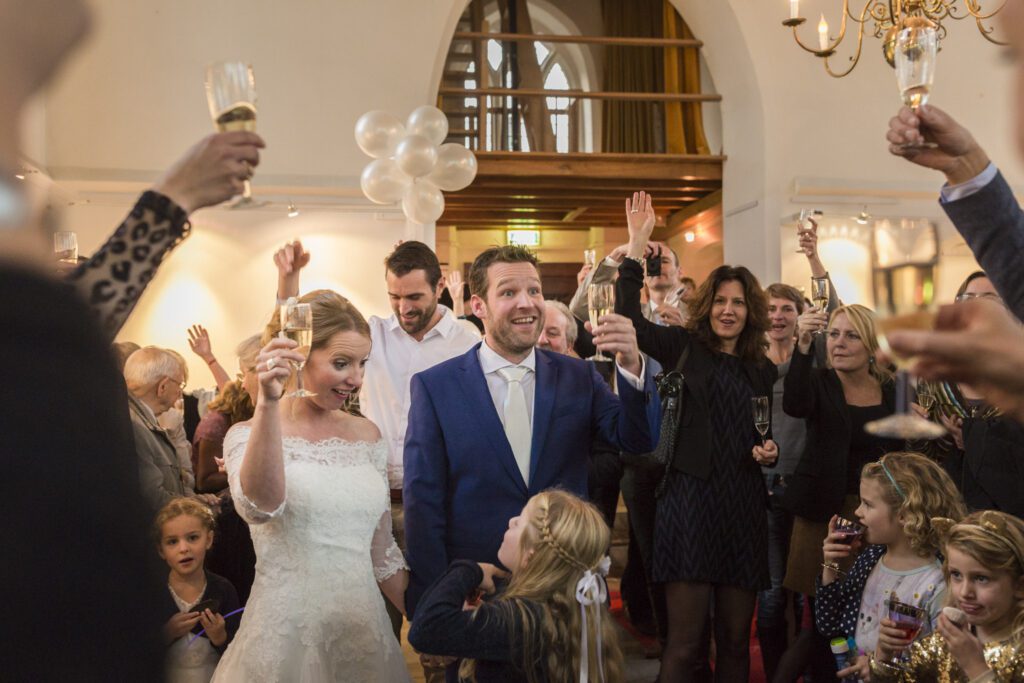 Bruid en bruidegom proosten met hun gastenin het kerkje van Persingen.