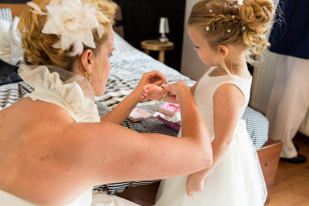 Bruid helpt haar dochter bij het omdoen van haar armband.