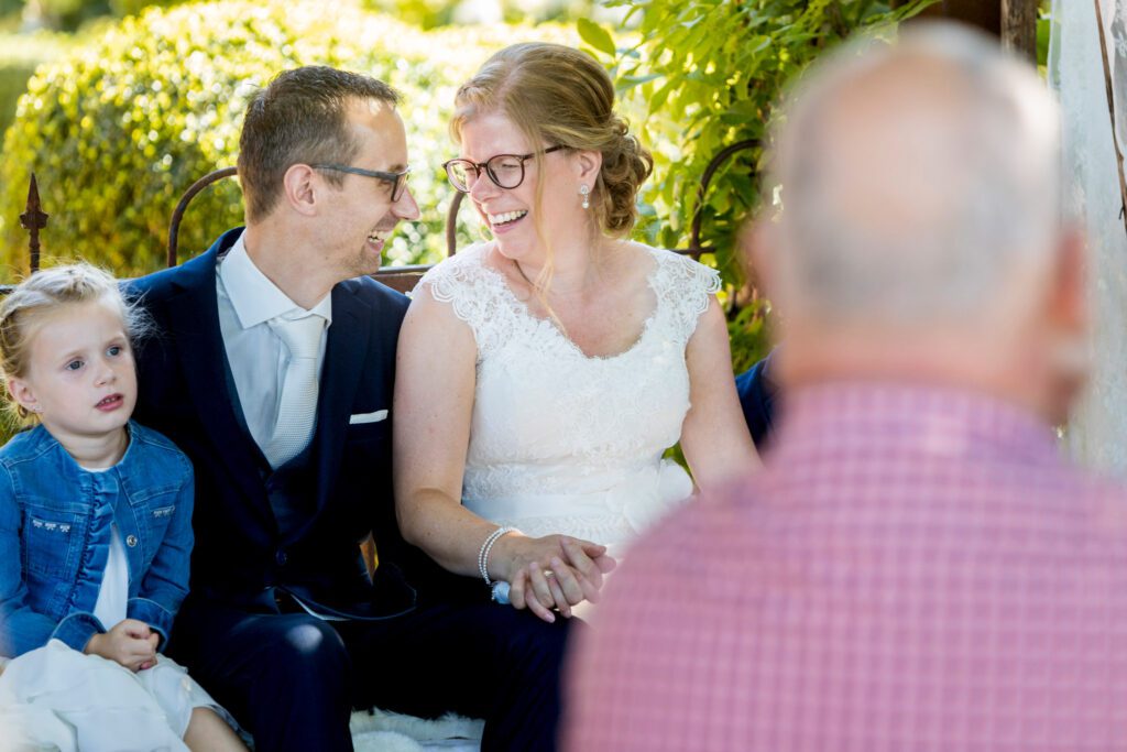 Bruidspaar kijkt elkaar verliefd aan tijdens de ceremonie.