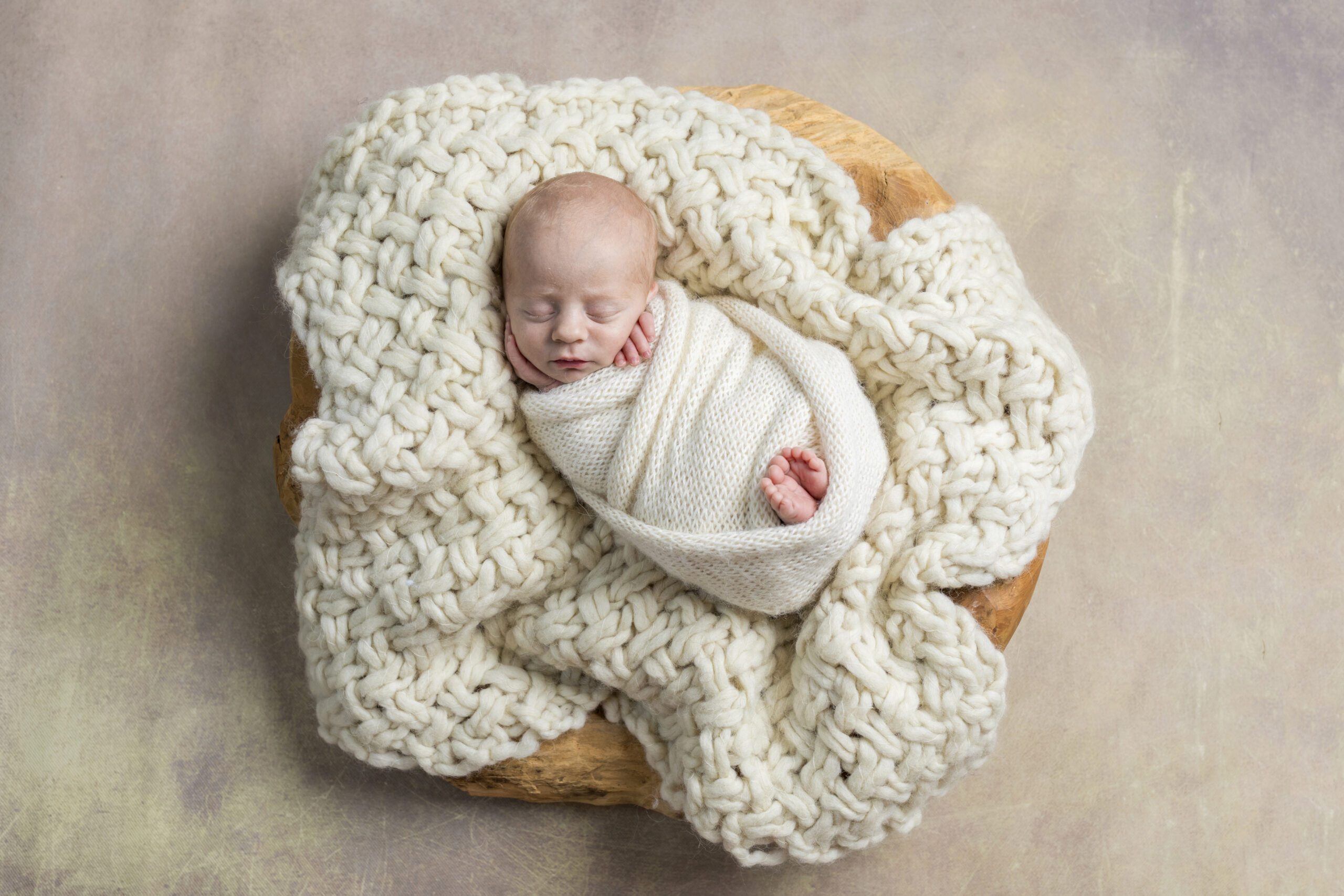 slapende baby ingebakerd in een wollen doek