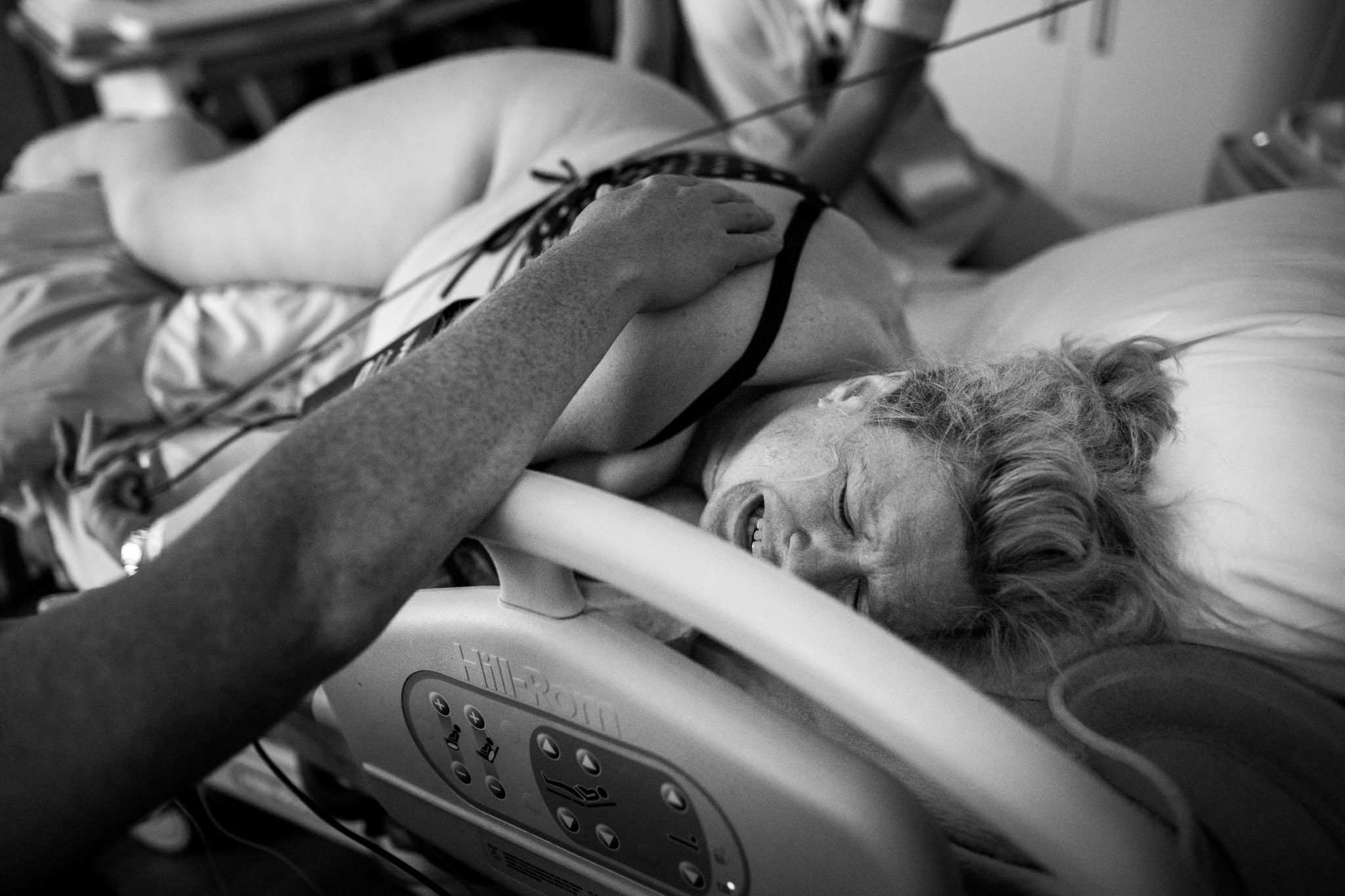 Man steunt zijn vrouw die pijn heeft tijdens het opvangen van de weeën