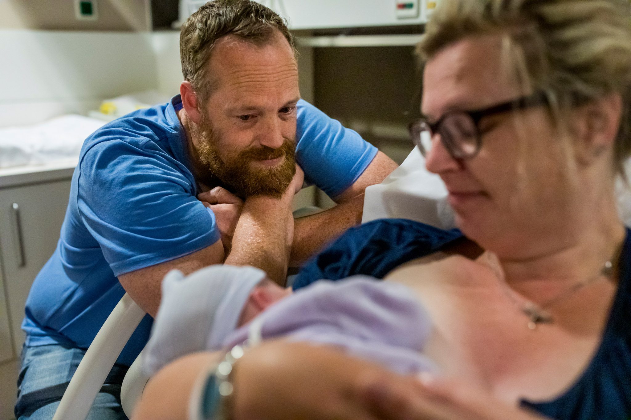 Kersverse papa bekijkt vol verwondering zijn pasgeboren dochter