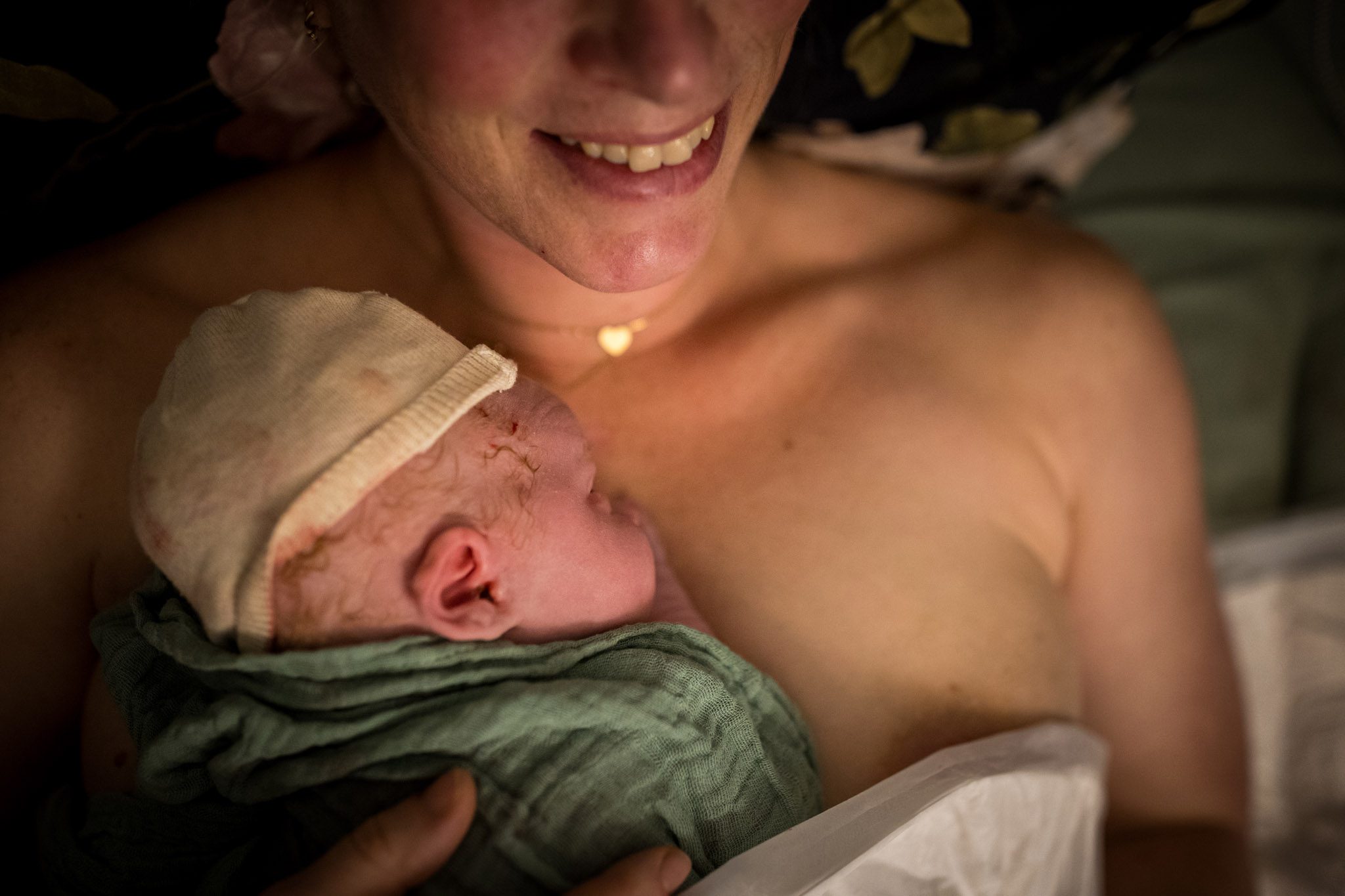 Baby ligt op de borst van mama bij te komen na de bevalling