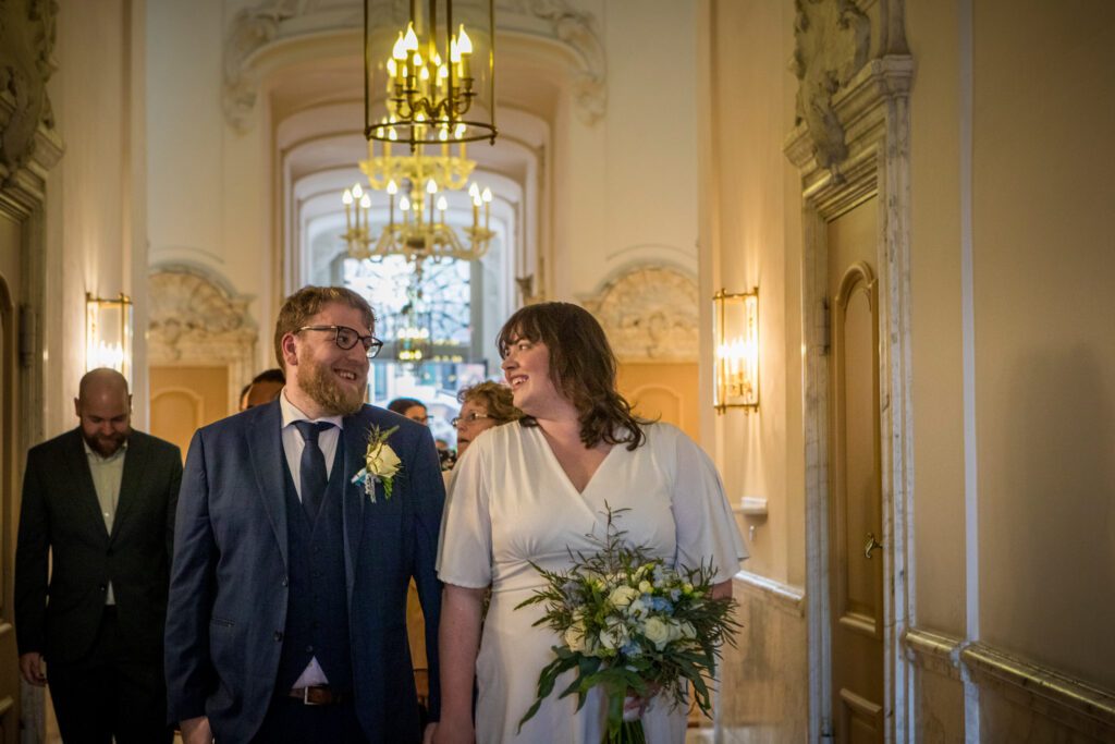 Bruidspaar loopt door de gang van het Oude Stadhuis in Den Haag na de ceremonie.