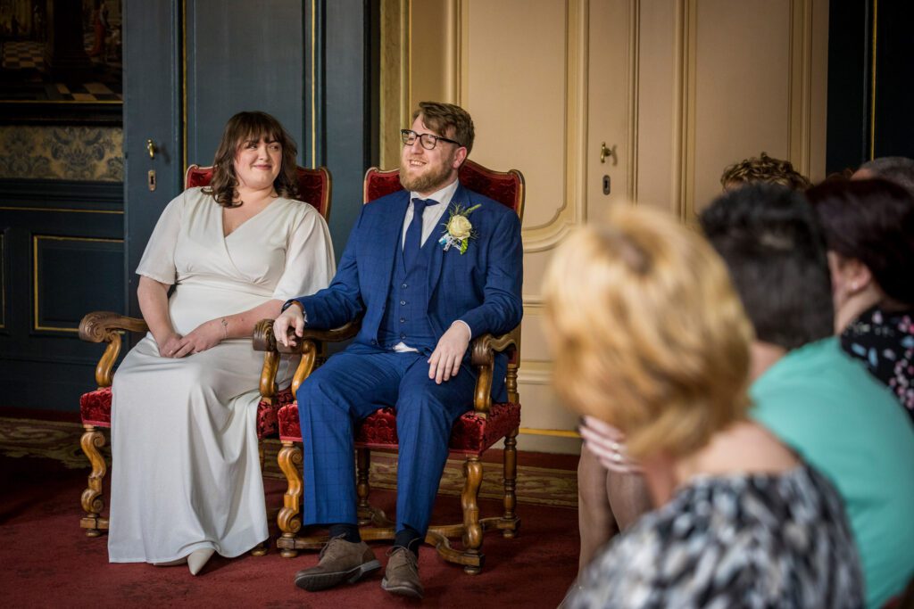 Bruidspaar zit in het Oude Stadhuis tijdens de huwlijksvoltrekking.