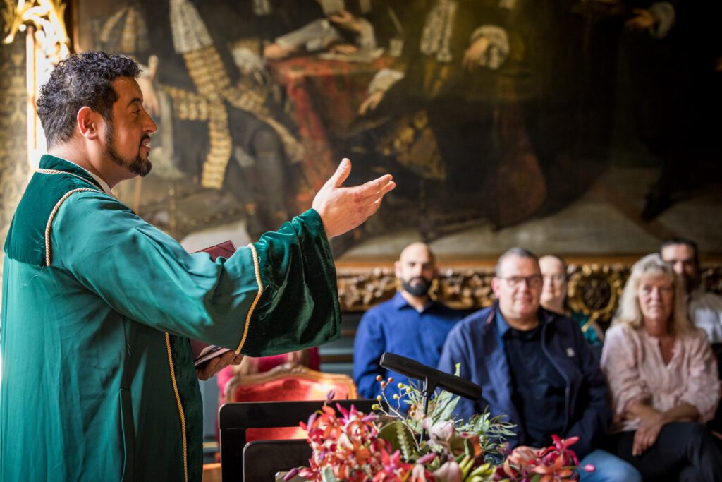 Ambtenaar heet het bruidspaar, familie en vrienden welkom in het Oude Stadhuis in Den Haag.