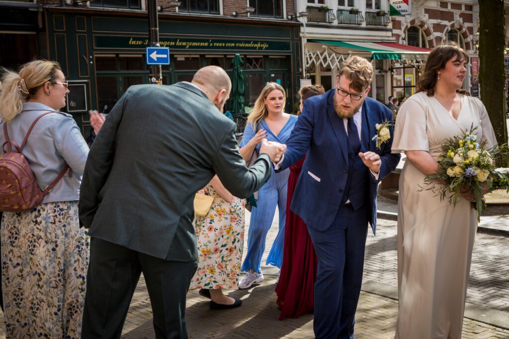 Bruidegom wordt met een boks gefeliciteerd na de ceremonie.
