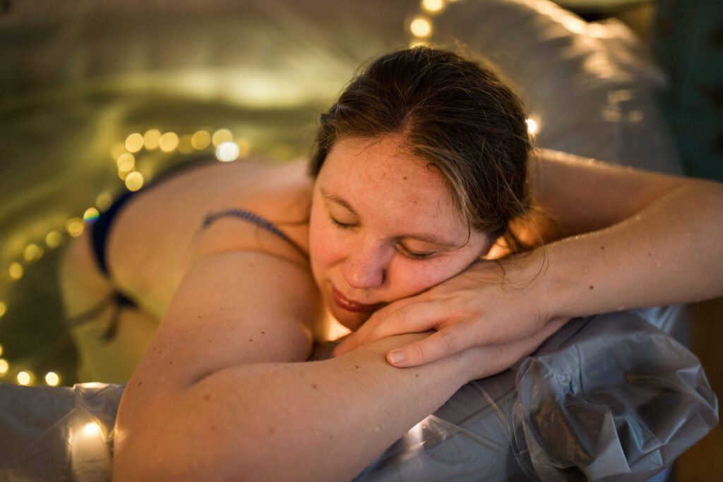 Vrouw rust uit tussen de weeën in het bevalbad
