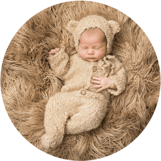 Baby ligt op zijn rug met berenpakje aan