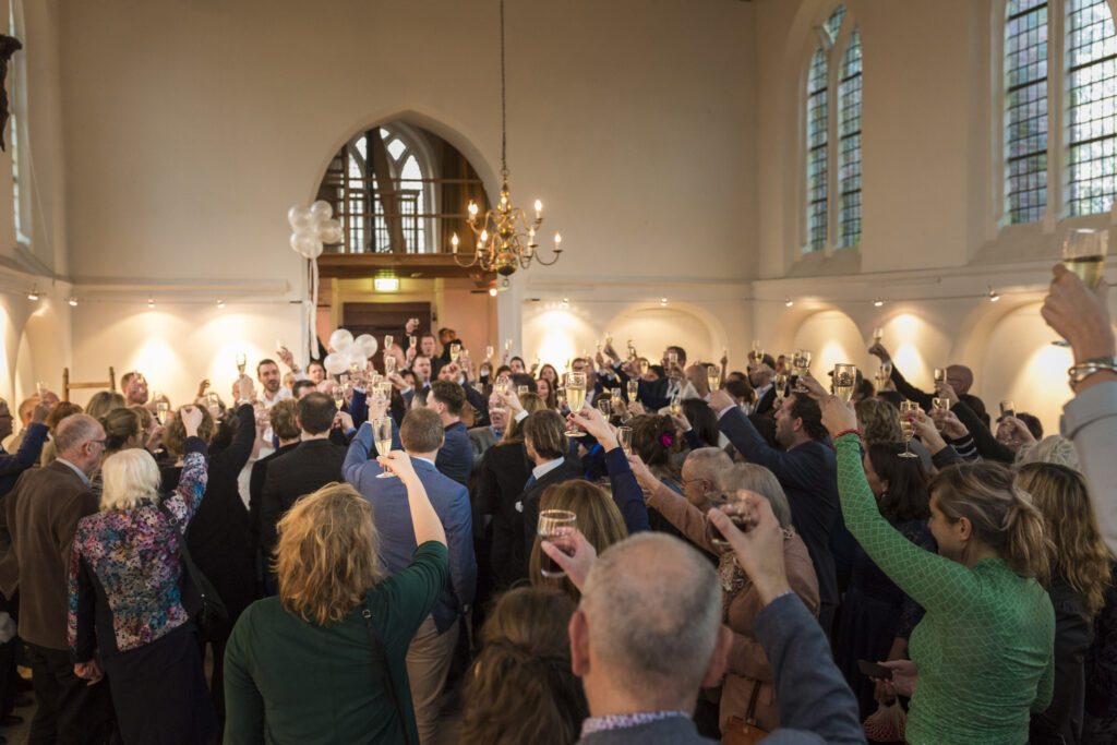 Bruid en bruidegom proosten met hun gastenin het kerkje van Persingen.