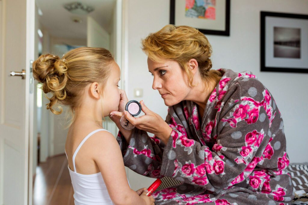 Bruid doet make-up op bij haar dochter.