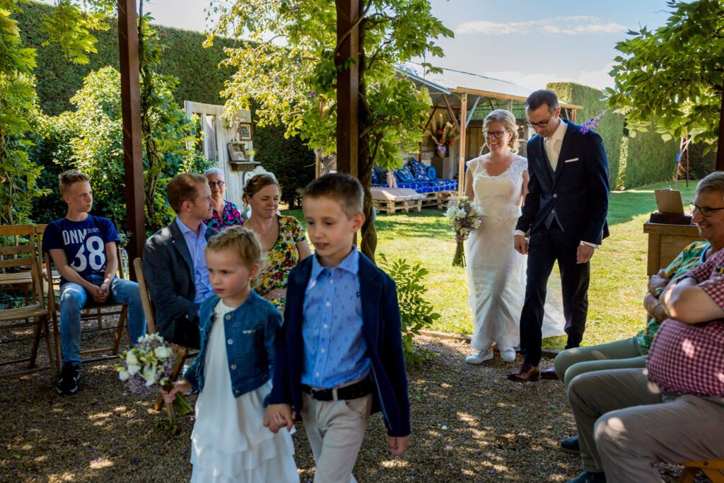 Bruidspaar loopt richting gasten voor de ceremonie.