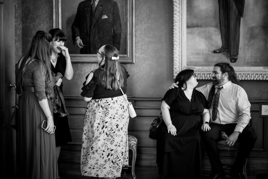 Bruiloftsgasten lachen en ontspannen voor de trouwceremonie.