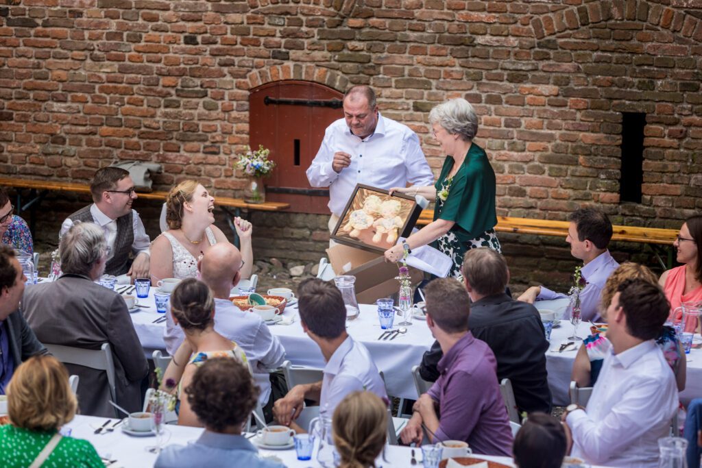 Ouders geven het bruidspaar een cadeau tijdens het diner.