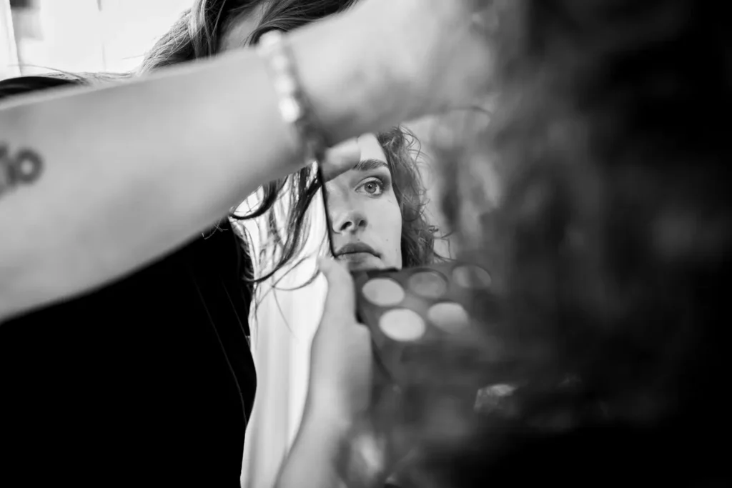 Bruid kijkt naar zichzelf in een spiegeltje. 