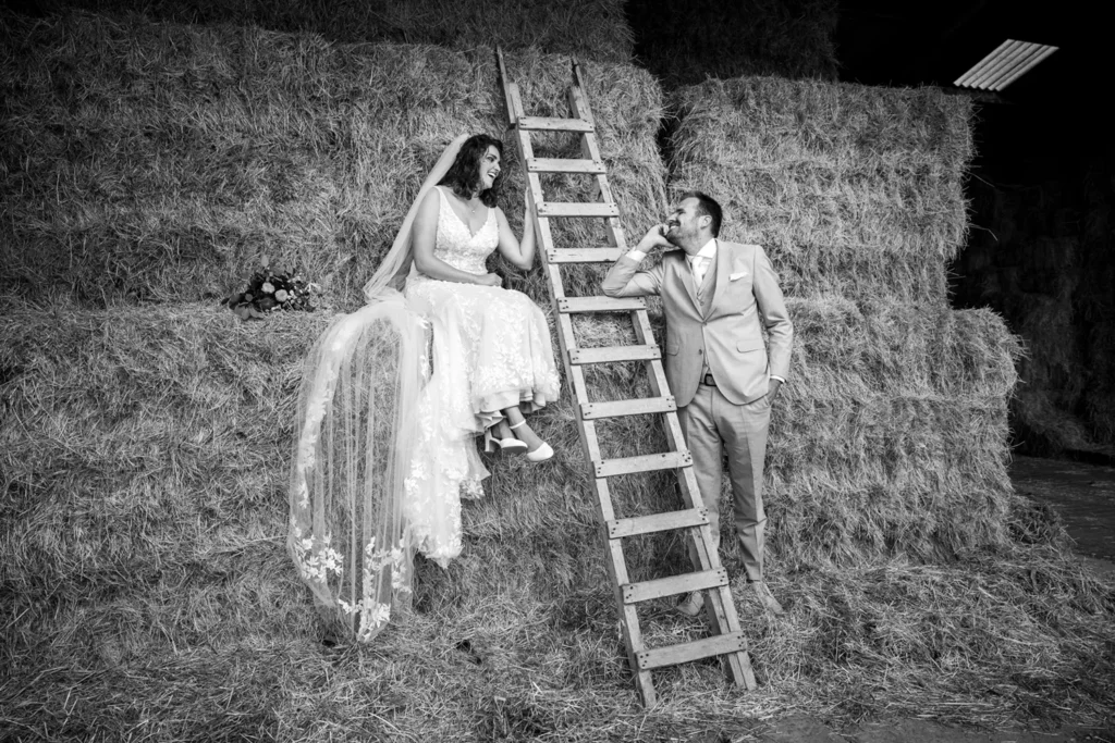 Bruidspaar kijkt naar elkaar tijdens een fotoshoot in het hooi.