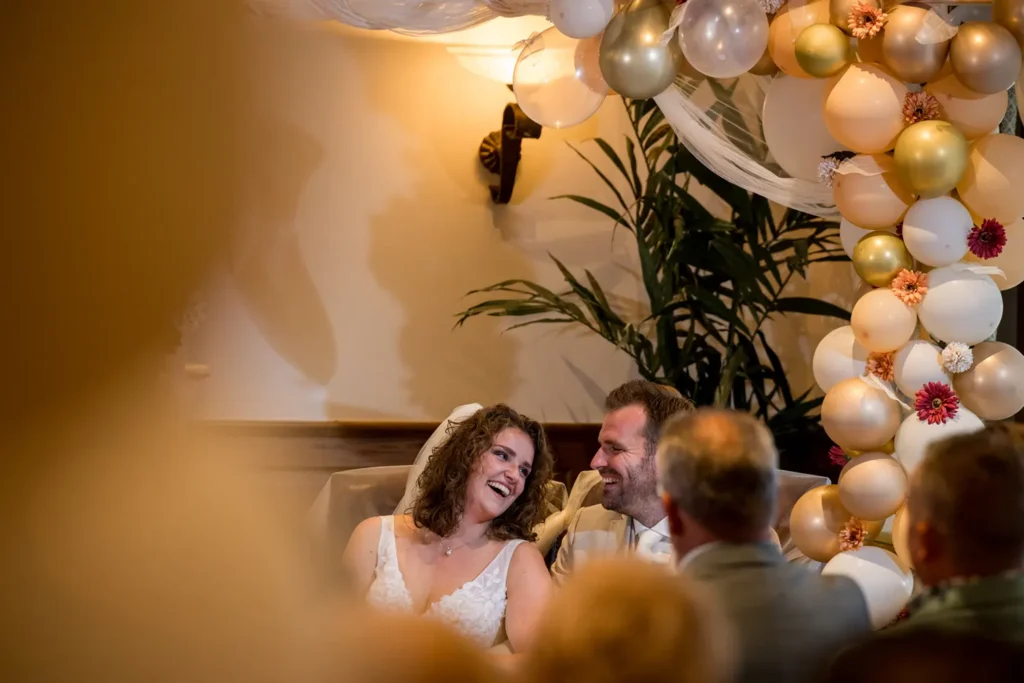 Bruidspaar lacht naar elkaar.