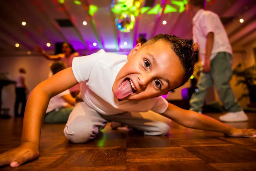 Jongetje kijkt recht in de camera op het trouwfeest.
