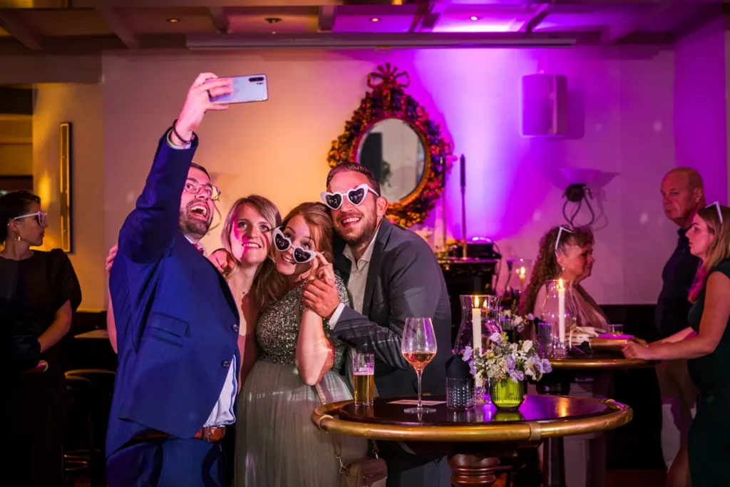 Groep vrienden maakt een selfie op een trouwfeest.