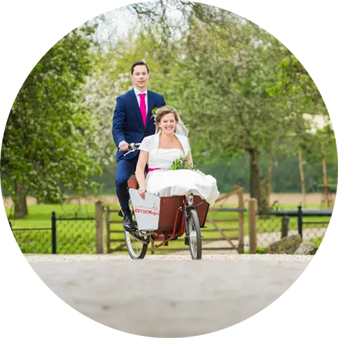 Bruidspaar komt op de bakfiets aan bij Slot Doddendael.webp