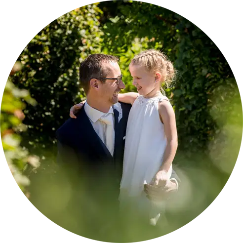 Vader en dochter lachen naar elkaar tijdens de trouwreportage.