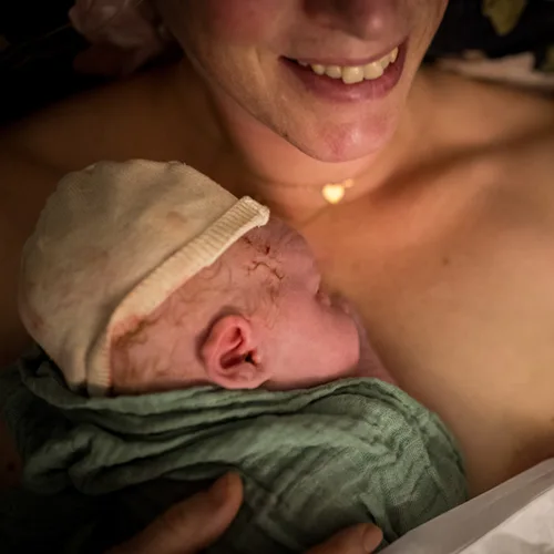 Pasgeboren baby ligt op de borst bij mama.
