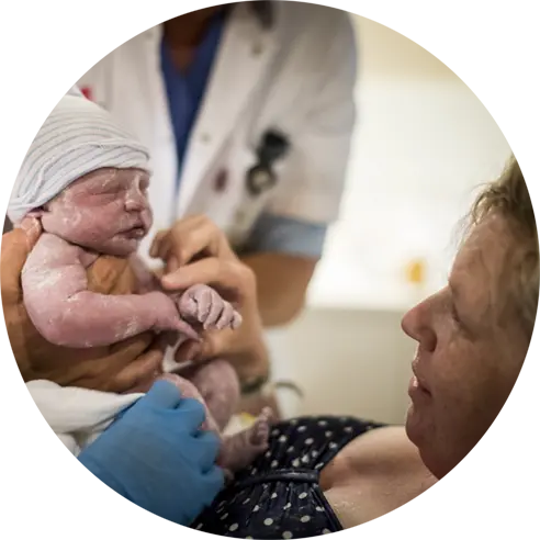 Moeder bekijkt haar pasgeboren dochter.