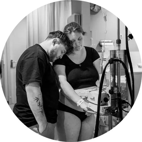 Man steunt zijn vrouw bij het opvangen van de weeën.