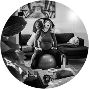 Man ondersteunt vrouw bij het opvangen van een wee met bevalbad op de voorgrond