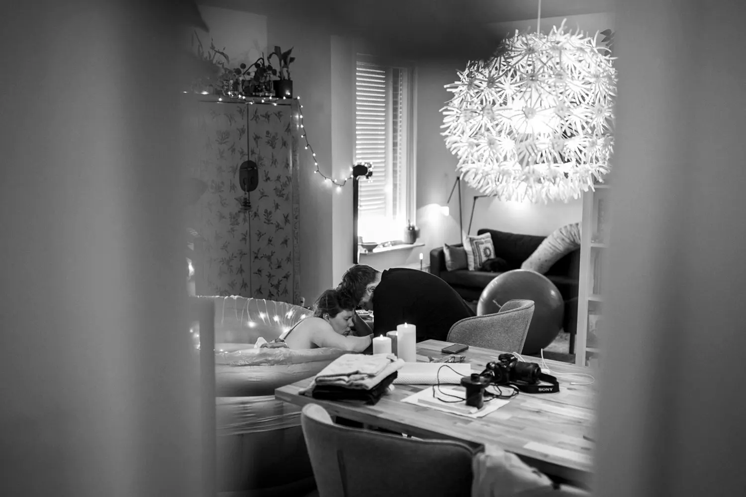 Man steunt zijn vrouw bij het opvangen van de weeën in een bevalbad.