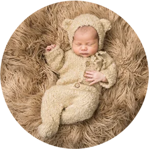 Baby ligt op zijn rug met berenpakje aan