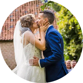 Bruidspaar kust elkaar tijdens de ceremonie na het ja-woord.