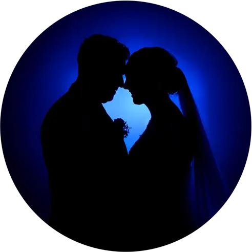 Silhouette van een bruidspaar voor een blauwe achtergrond.