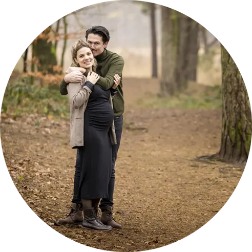 Man en vrouw knuffelen tijdens de zwangerschapsshoot